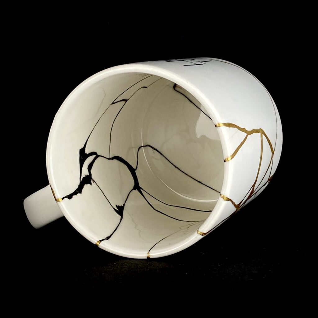 Aufsicht auf der weißen Herzensmensch-Tasse mit Kintsugi-Goldlinien